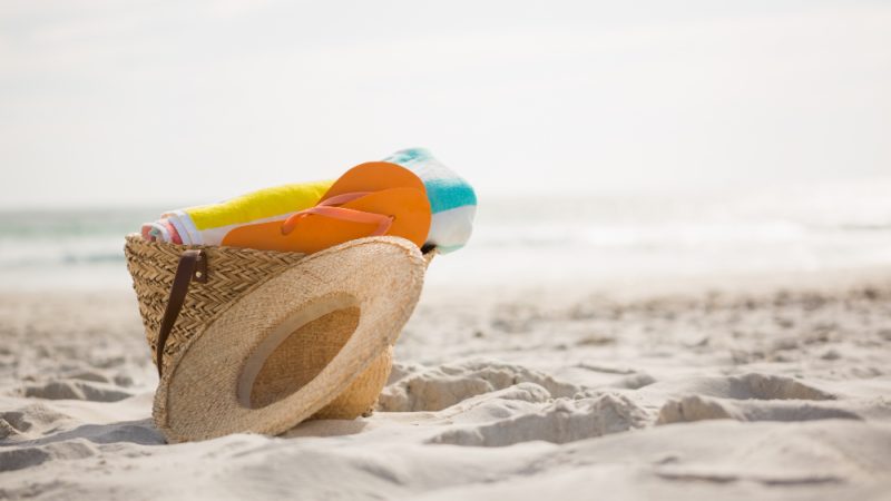 Saco com acessórios de praia mantidos na areia awesomecontent freepik ferias